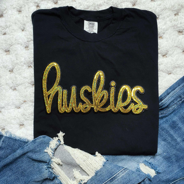 Huskies Gold Sequins Patch, black T-shirt with gold sequin embroidered Huskies logo.