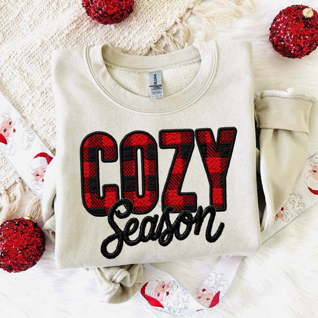 Buffalo Plaid Cozy Season Faux Embroidery DTF Heat Transfer, festive holiday sweater with embroidered red and black plaid text saying 'COZY Season' on a cream background.
