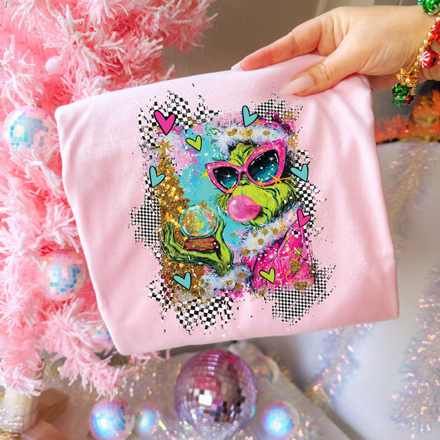 Bubblegum Snow Globe Green Guy DTF Heat Transfer, colorful graphic of a green dog wearing pink sunglasses blowing bubbles on pink fabric.