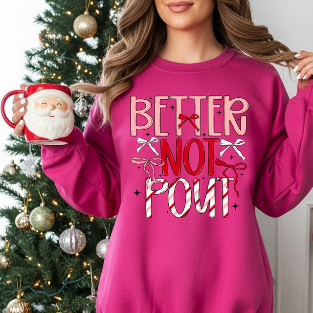 Better Not Pout Pattern DTF Heat Transfer, colorful Christmas-themed design on a woman's pink sweatshirt with Christmas decorations in the background.