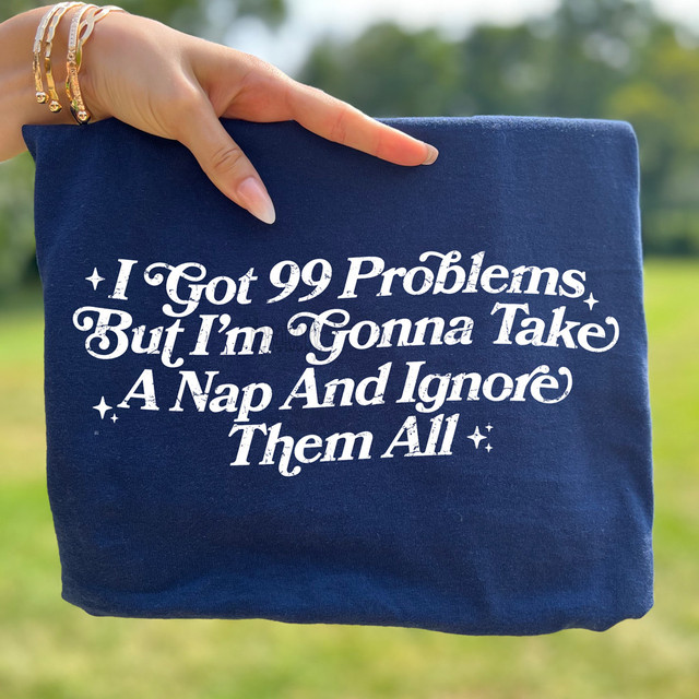 Distressed I Got 99 Problems But I'm Gonna Take A Nap And Ignore Them All DTF Heat Transfer, navy blue fabric with white text design.