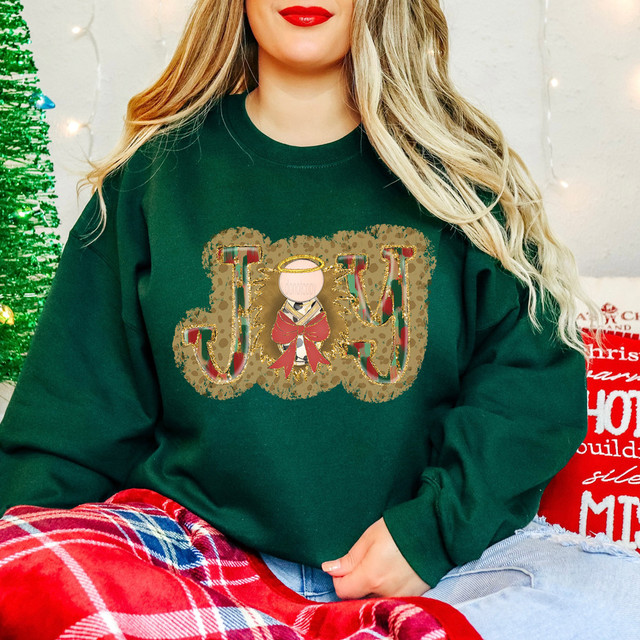 Joy Baby Jesus DTF Heat Transfer, Christmas-themed design on a green sweatshirt featuring a cute baby Jesus illustration with festive letters 'J' and 'Y' decorated with Christmas patterns and a gold halo