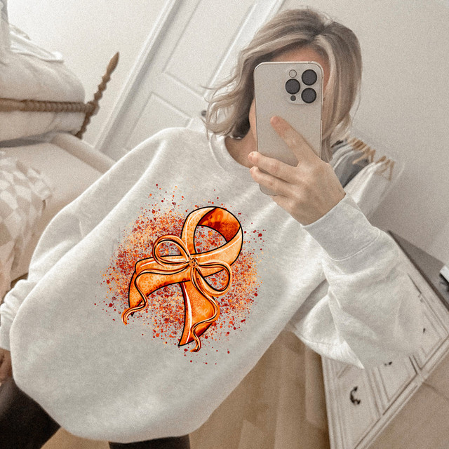Orange Ribbon Bow DTF Heat Transfer, vibrant orange ribbon bow design on a white sweatshirt.