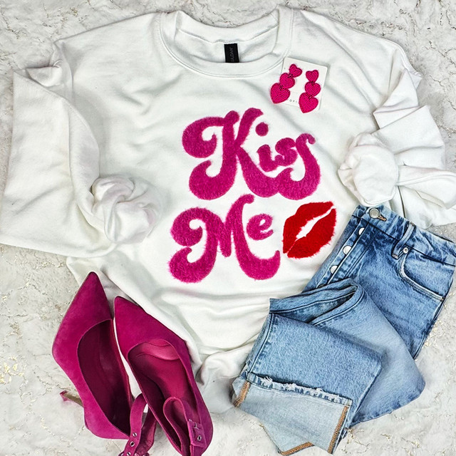 Kiss Me Fluffy Patch with Red Lip, pink fluffy patch in the shape of a kiss and red lips patch on a white sweatshirt, paired with blue jeans and pink high heels.