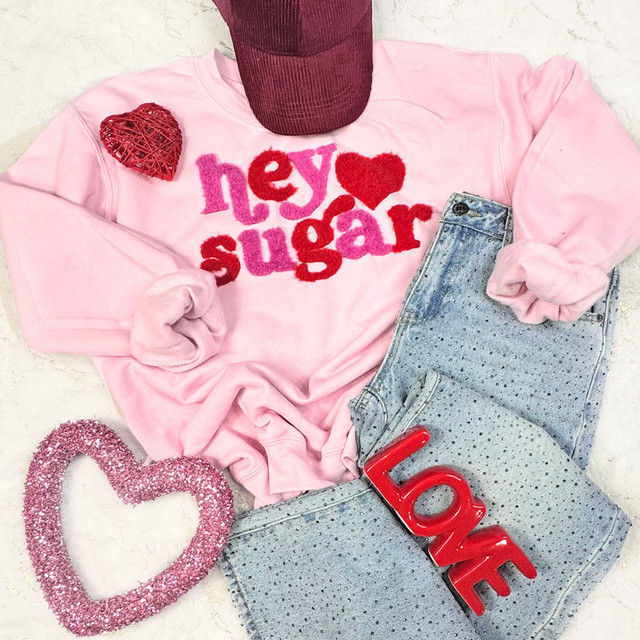 Hey Sugar Two Tone Fluffy Patch, pink sweatshirt with red and pink felt lettering and heart patches, paired with light blue dotted denim shorts, a maroon cap, a pink glitter heart-shaped accessory, and a red LOVE sign.