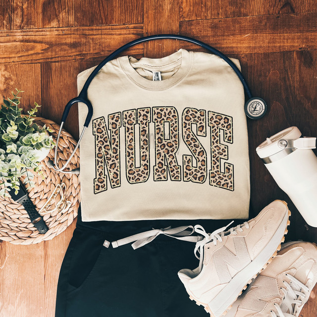 Leopard Nurse DTF Heat Transfer, leopard print design on a beige t-shirt with athletic shoes, stethoscope, and accessories.