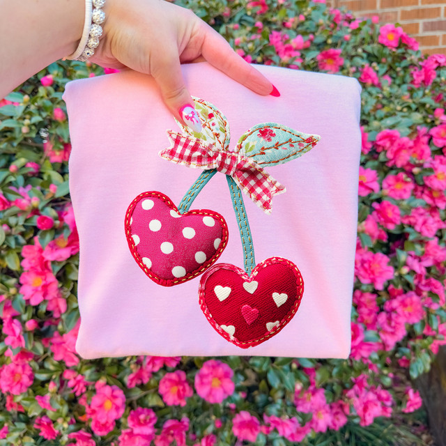 Faux Embroidery Patterned Red Heart Cherries DTF Heat Transfer, fabric with cherry embroidery featuring heart-shaped fruits with polka dot and heart patterns and a gingham bow, applied to pink textile.