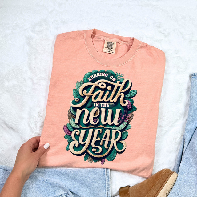 Running On Faith In The New Year DTF Heat Transfer, on a pink t-shirt with a colorful graphic design.
