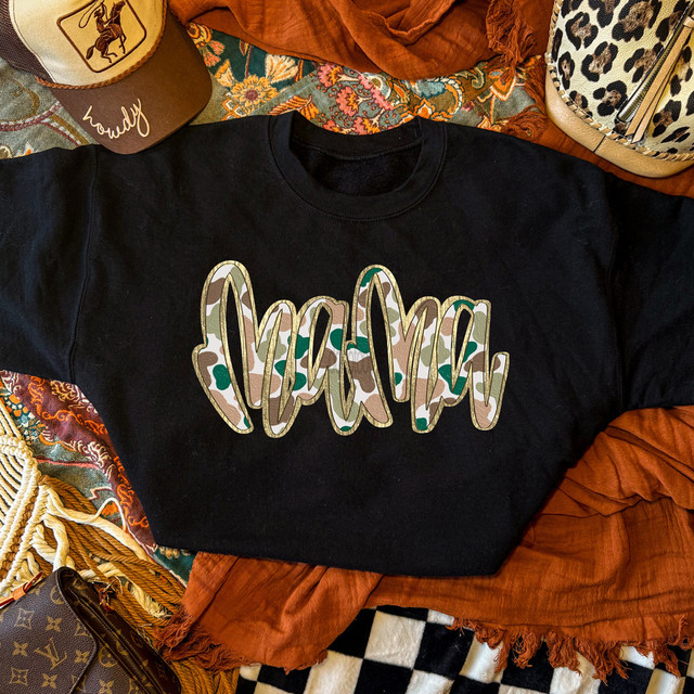 Mama Script Camo Faux Gold Metallic DTF Heat Transfer, a black T-shirt with the word 'Mama' in playful camo and faux gold metallic finish, surrounded by trendy accessories and colorful fabrics.