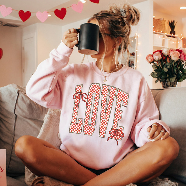 Checkerboard Love Leopard Outline DTF Heat Transfer, stylish design of the word 'Love' with checkerboard pattern and leopard outline on a pink sweatshirt.