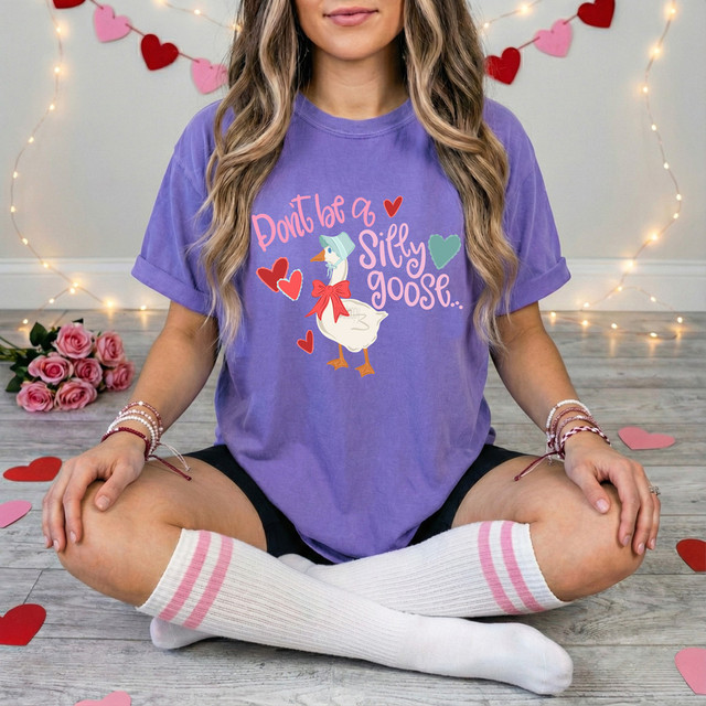 Valentines Don't Be A Silly Goose DTF Heat Transfer, woman wearing purple t-shirt with Valentine's themed goose graphic and hearts design.