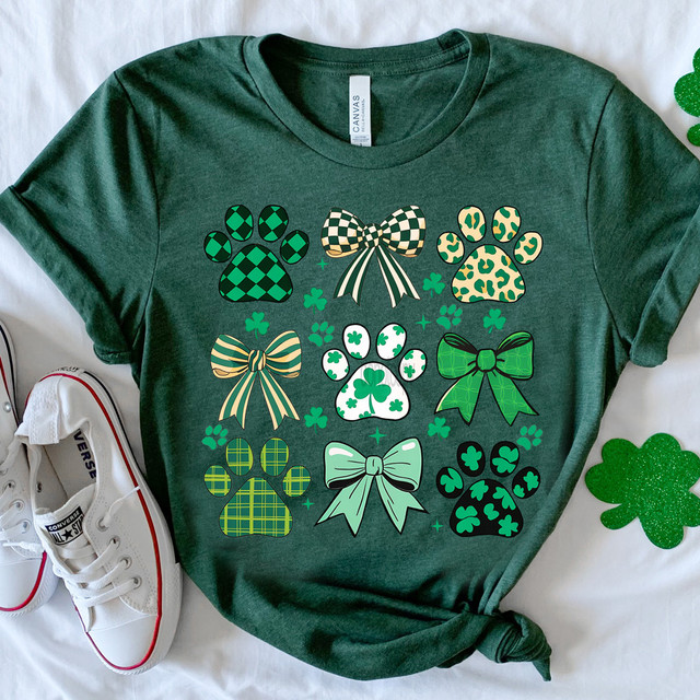 Patterned Shamrock Paw Prints DTF Heat Transfer, green pet paw print and bow designs with shamrock patterns on a dark green T-shirt.