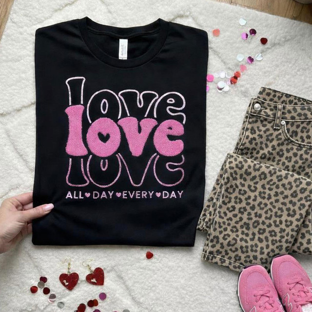 Love Love Love Glitter Fluffy Patch, black T-shirt with pink and purple glitter fluffy text and hearts, paired with leopard print pants, pink shoes, and scattered colorful confetti.
