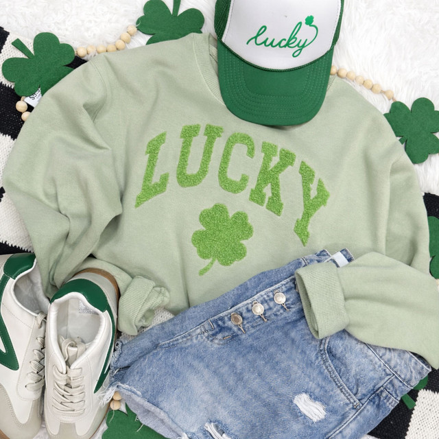 Lucky Shamrock Fluffy Patch, festive St. Patrick's Day clothing set with a green sweatshirt, cap, denim shorts, and sneakers featuring shamrock and lucky designs.