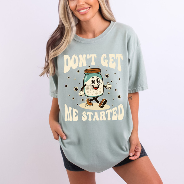Don't Get Me Started DTF Heat Transfer, a humorous graphic of a cheerful cartoon jar character with a thumbs-up, on a woman's casual t-shirt.