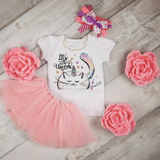 Let's Just Be Unicorns Kitty Unikitty Cat Sublimation Transfer, a cute white children's t-shirt with a colorful unicorn and cat design, surrounded by pink tulle tutu and pink paper rose decorations.