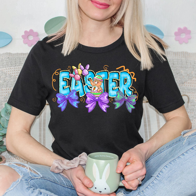 Easter Bear Bows DTF Heat Transfer, colorful Easter-themed design with a bear, balloons, bows, and vibrant colors on a black T-shirt.