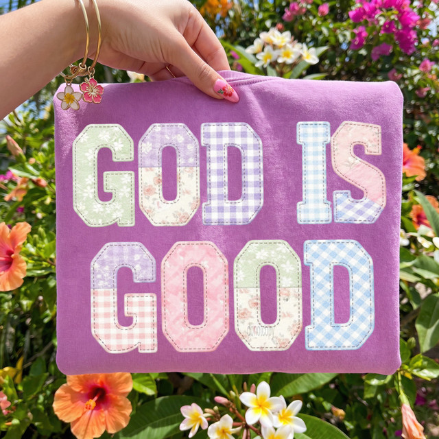 Faux Fabric Patchwork God Is Good DTF Heat Transfer, colorful patchwork letters on purple fabric with floral background.