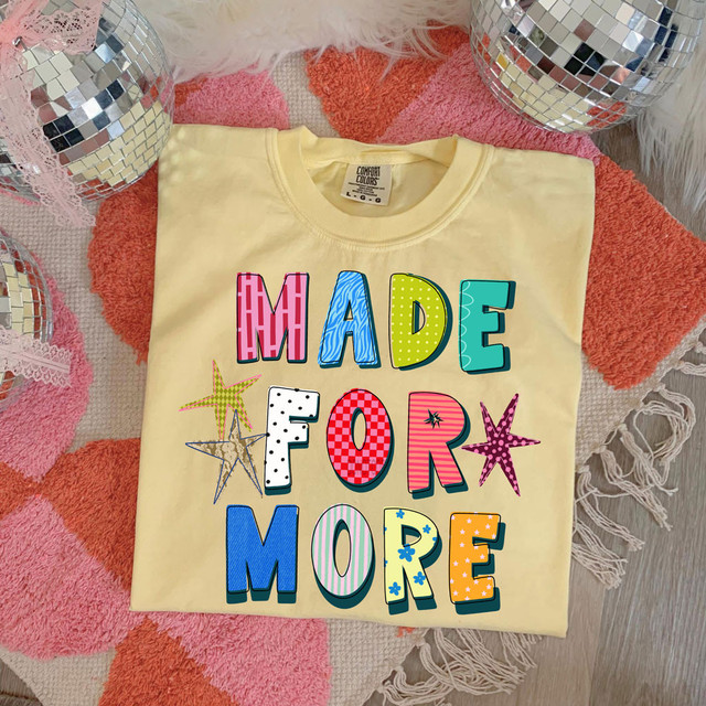 Made For More DTF Heat Transfer, colorful and vibrant heat transfer design on a creamy yellow t-shirt featuring the phrase 'Made For More' with star accents.