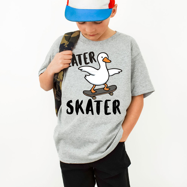 Later Skater DTF Heat Transfer, a young boy wearing a graphic t-shirt with a cartoon duck skateboarding and the words "Skater" and "Later" printed on it.