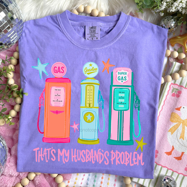 Retro That's My Husband's Problem DTF Heat Transfer, colorful vintage gas pumps design on a purple T-shirt showcasing humorous graphic art.