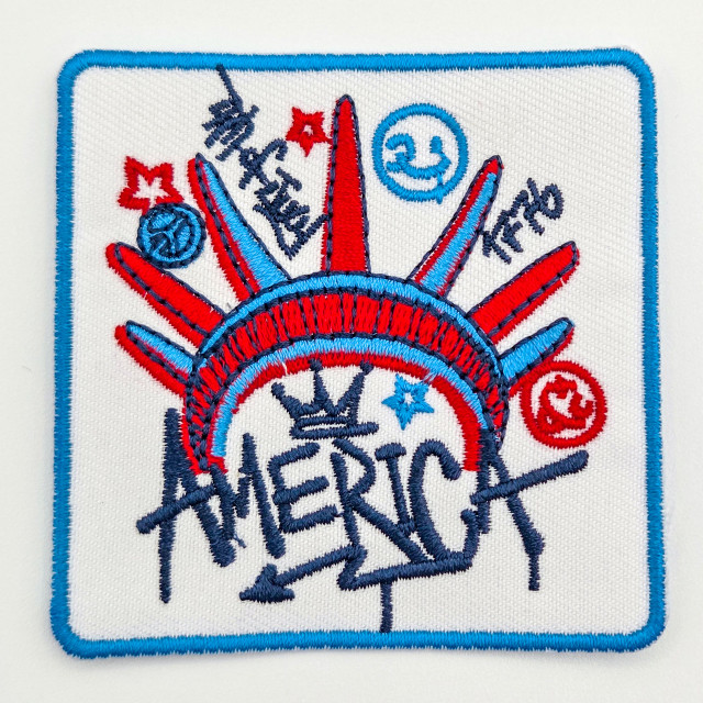 America Graffiti Embroidered Hat Patch – 3” Wide, colorful embroidered patch featuring a stylized American flag with red, white, and blue colors and various patriotic symbols.