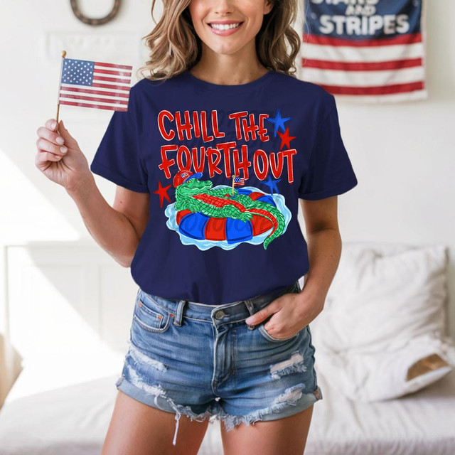 Chill The Fourth Out Gator DTF Heat Transfer, vibrant design on navy blue T-shirt featuring a green alligator relaxing in a float with American patriotic themes and text.