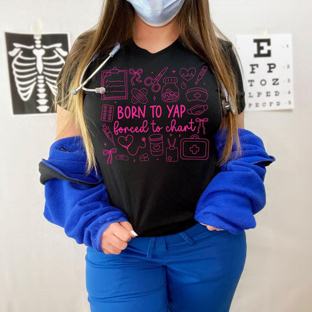 Born To Yap Forced To Chart PINK DTF Heat Transfer, pink line art medical-themed icons on a black t-shirt worn by a person with a stethoscope and medical poster in the background.