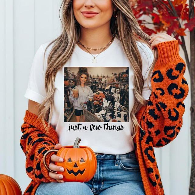 Just A Few Things Halloween DTF Heat Transfer, woman holding a pumpkin mug and wearing a white t-shirt with a Halloween-themed print.