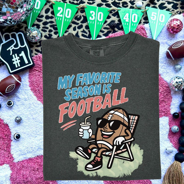 My Favorite Season Is Football Retro DTF Heat Transfer T-shirt with a cartoon football character relaxing with sunglasses and holding a drink, surrounded by football-themed decor and celebrating football season.