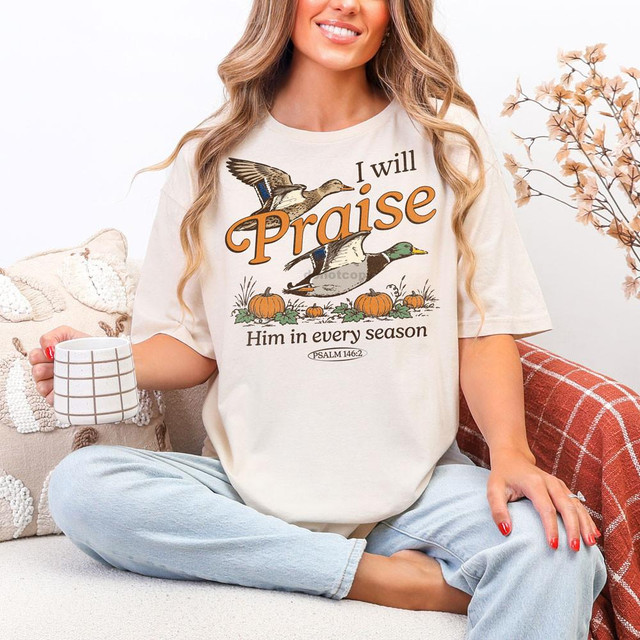 I Will Praise Him In Every Season Fall DTF Heat Transfer, a woman wearing a cream T-shirt with fall-themed ducks, pumpkins, and scripture design.