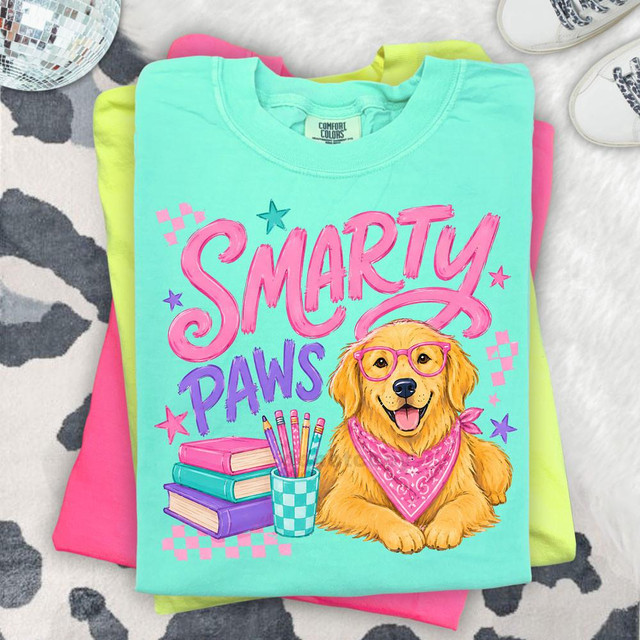 Smarty Paws DTF Heat Transfer, colorful graphic T-shirt with a cute golden retriever wearing glasses and a bandana, with books and pencils, designed for pet lovers and DIY apparel customization.