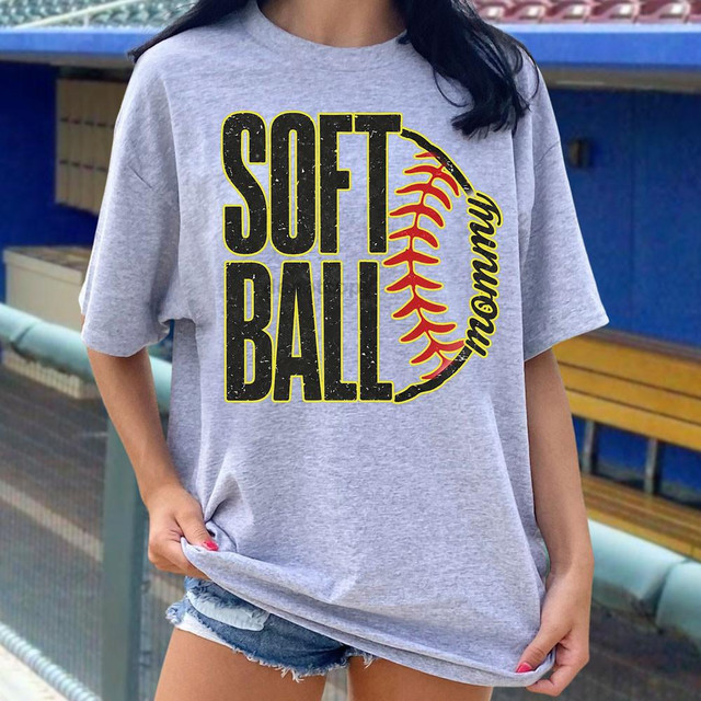 Softball Mommy DTF Heat Transfer, graphic design on a gray T-shirt featuring the text 'Softball' with a half-stitched softball and 'Mommy' written vertically, appropriate for sports-themed apparel.