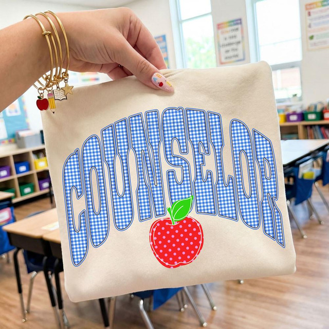 Gingham Apple School Staff DTF Heat Transfer, school staff tote bag with gingham apple design and blue checkered lettering in a classroom setting.