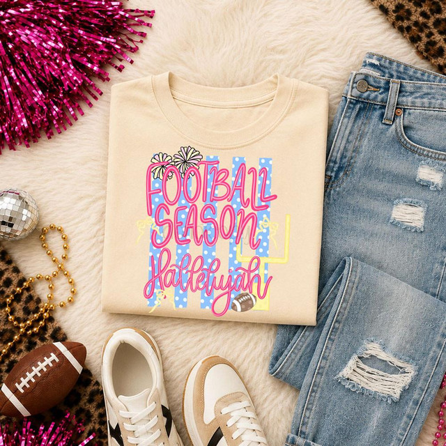 Football Season Hallelujah DTF Heat Transfer, colorful design on a cream-colored t-shirt surrounded by casual denim jeans, sneakers, mini football, and festive decorations.