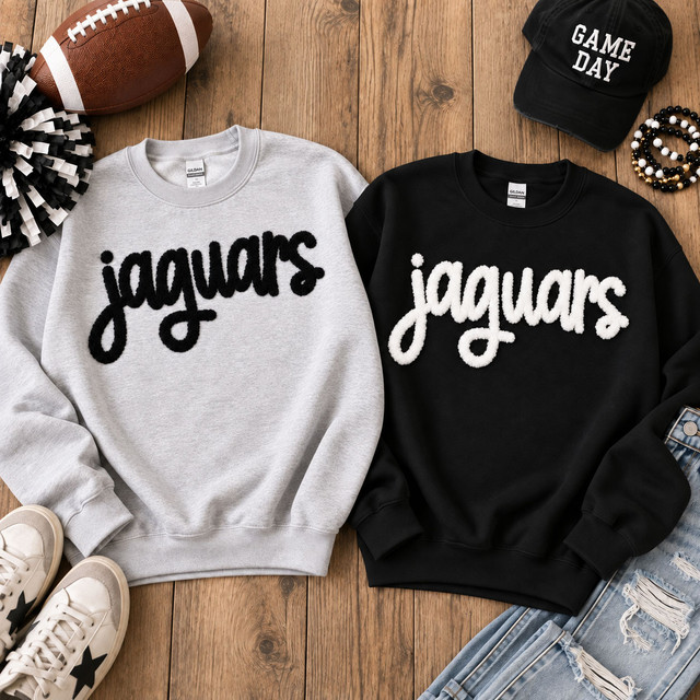 Black Jaguars fluffy script patch displayed on a light gray sweatshirt beside a white Jaguars fluffy script patch on a black sweatshirt.