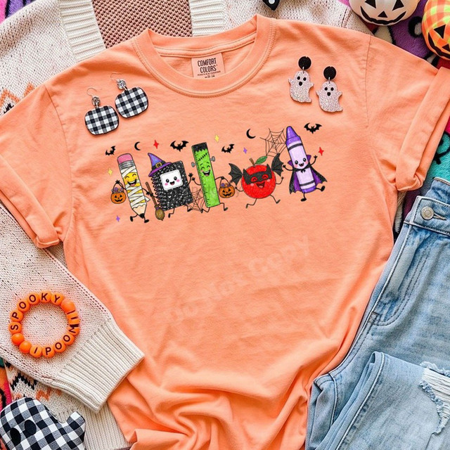 Back-to-school Halloween DTF transfer featuring costumed school supply characters including a mummy pencil, witch notebook, Frankenstein ruler, vampire apple, and caped crayon