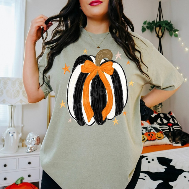 Black and white striped pumpkin DTF transfer with orange bow and stars in a hand-painted fall design