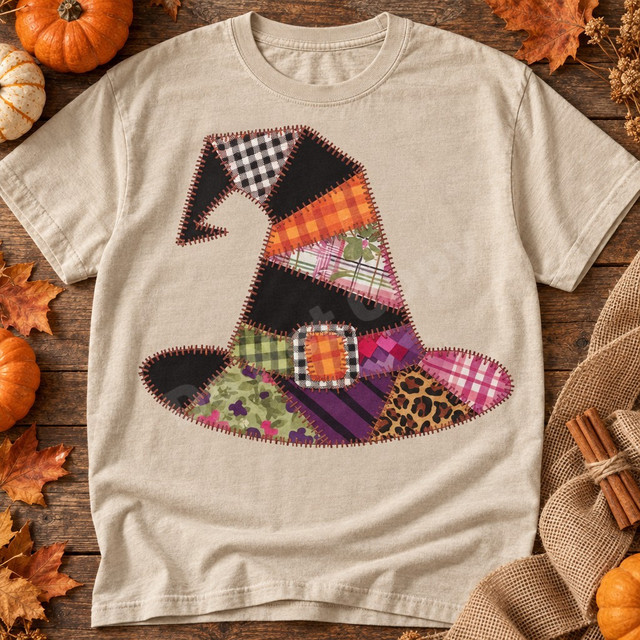Patchwork witch hat DTF transfer with plaid, gingham, floral, and leopard fabric patches joined by orange whip-stitching and a plaid buckle Shown on a Sandstone t-shirt.