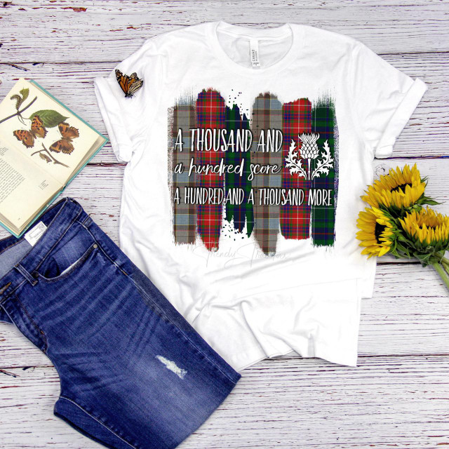 Outlander TV show fan art T-shirt featuring a colorful plaid brush stroke quote design with the words "A hundred and a thousand more" and a floral graphic, sublimation transfer.
