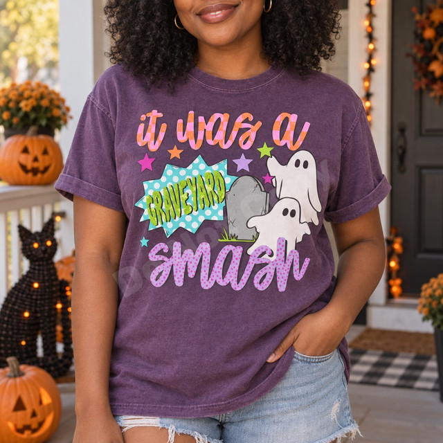 It Was a Graveyard Smash Halloween DTF transfer with cute ghosts, a cracked tombstone, colorful stars, and a teal polka-dot comic burst in bouncy lettering Shown on a Grape t-shirt.