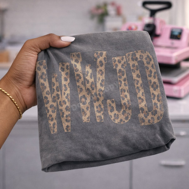 WWJD DTF transfer in distressed leopard print lettering on a grey shirt