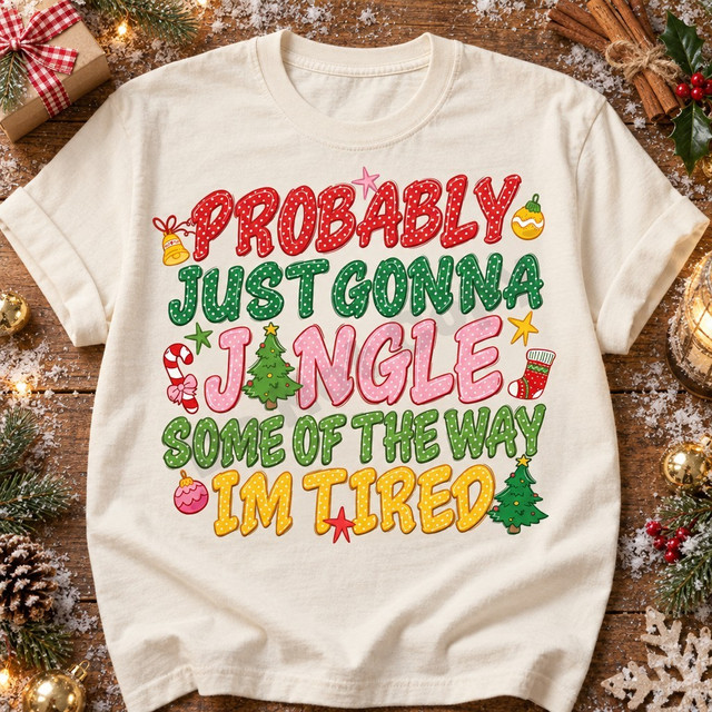 Probably Just Gonna Jingle Some Of The Way Im Tired Christmas DTF transfer in stacked polka-dot varsity lettering with hand-drawn ornaments, bell, candy cane, stocking, stars, and mini Christmas trees Shown on a Ivory t-shirt.