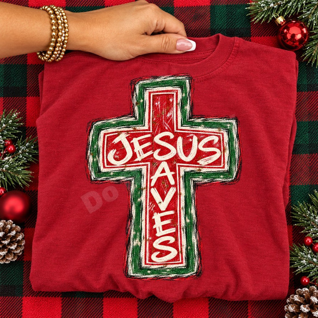 Jesus Saves distressed cross DTF transfer in red, green, and cream with weathered hand-drawn Christmas-inspired texture Shown on a Crimson t-shirt.