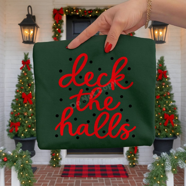 Deck the Halls Christmas DTF transfer in red script lettering with black polka dots on a green shirt