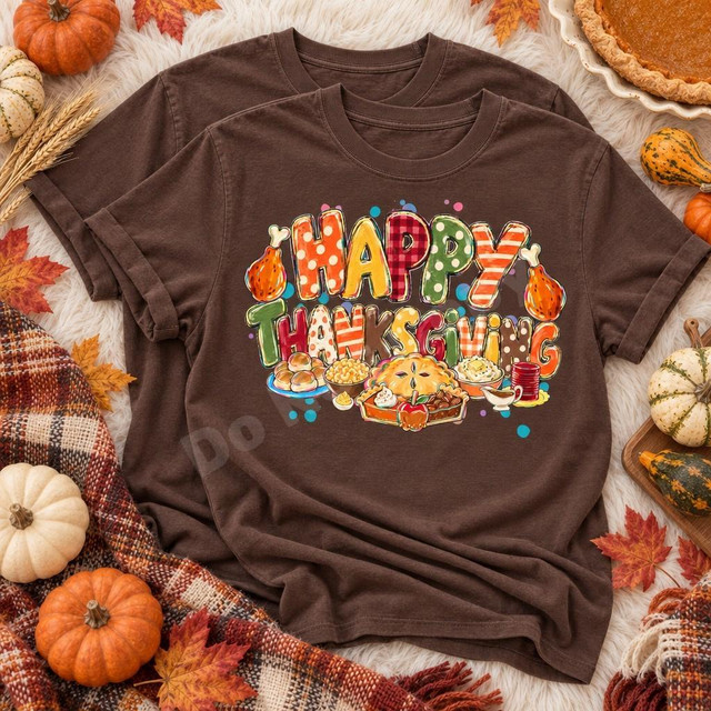 Happy Thanksgiving DTF Transfer | Hand-Painted Turkey & Holiday Feast Design, colorful hand-painted “Happy Thanksgiving” lettering with a roast turkey and festive feast printed on a brown T-shirt surrounded by autumn leaves and pumpkins.