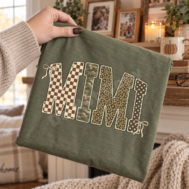 MIMI block letter DTF transfer with checkerboard, camo, leopard, and polka dot patterns, cream outlines, and ivory ribbon bows on an olive shirt Shown on a Moss t-shirt.