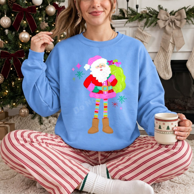 Preppy Santa DTF transfer with pink Santa hat and suit trim, striped leggings, and boots carrying a gift sack, surrounded by colorful snowflakes and stars