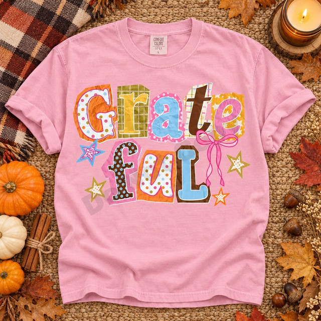 Grateful scrapbook-style word art DTF transfer with mixed-pattern paper-cut letters, pink ribbon bow, and stars in autumn pastel colors Shown on a Blossom t-shirt.