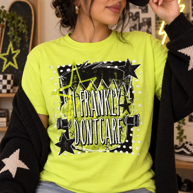 I Frankly Don't Care grunge DTF transfer with distressed lettering, neon green star splatter background, black stars, and skateboard truck graphics Shown on a Neon Lemon t-shirt.